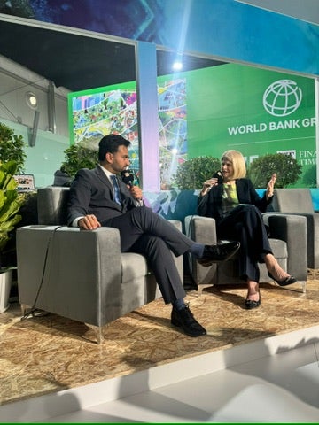 Picture of a man and a woman speaking on stage at a world green bank stage in Baku.