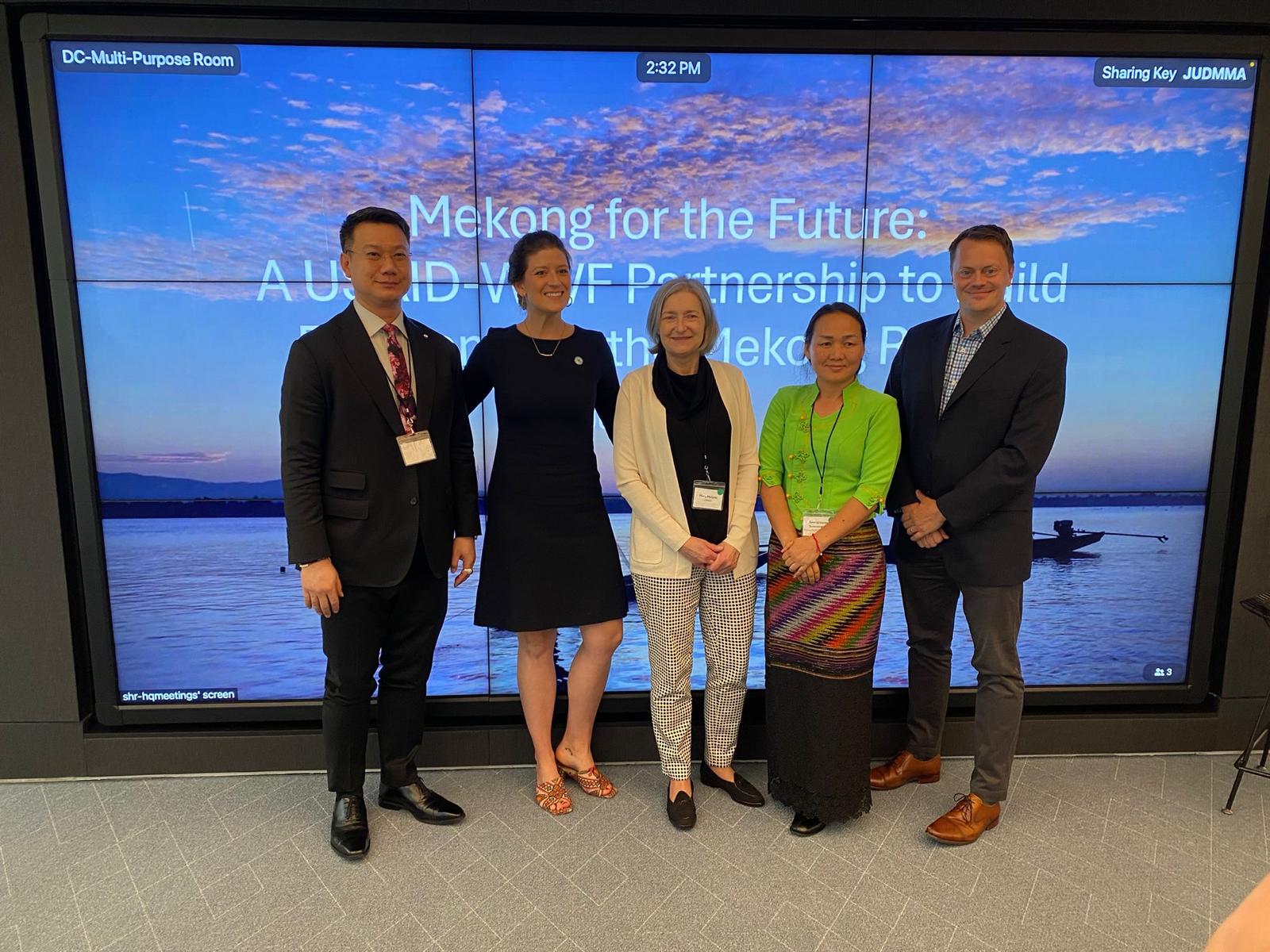 Standing with group of men (March 2023)